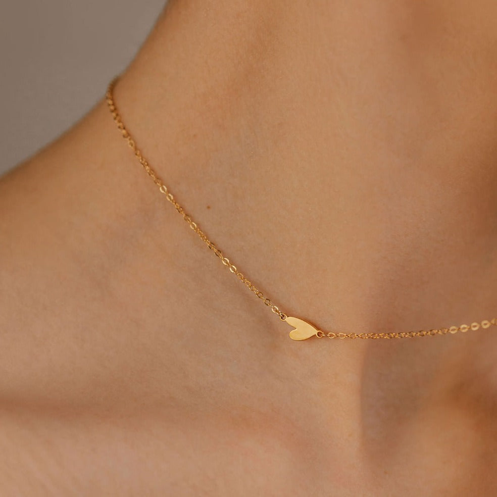 a women neck with a sideways heart necklace