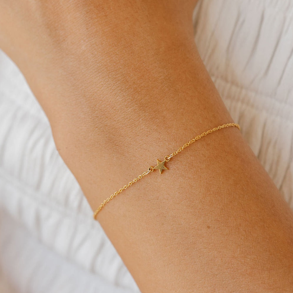a woman is wearing a sideways star bracelet made in Canada