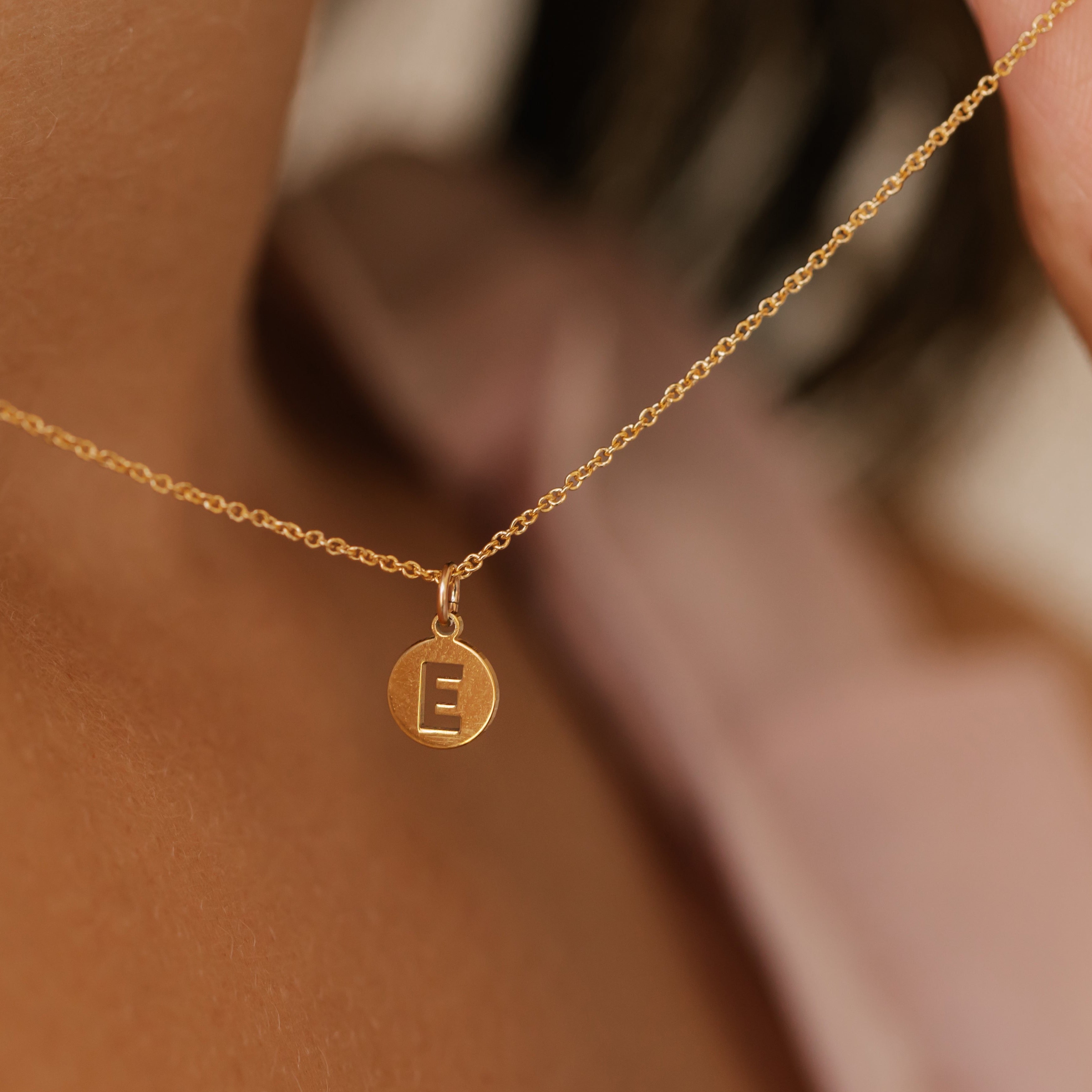 an initial E coin gold necklace sustainably made in Canada