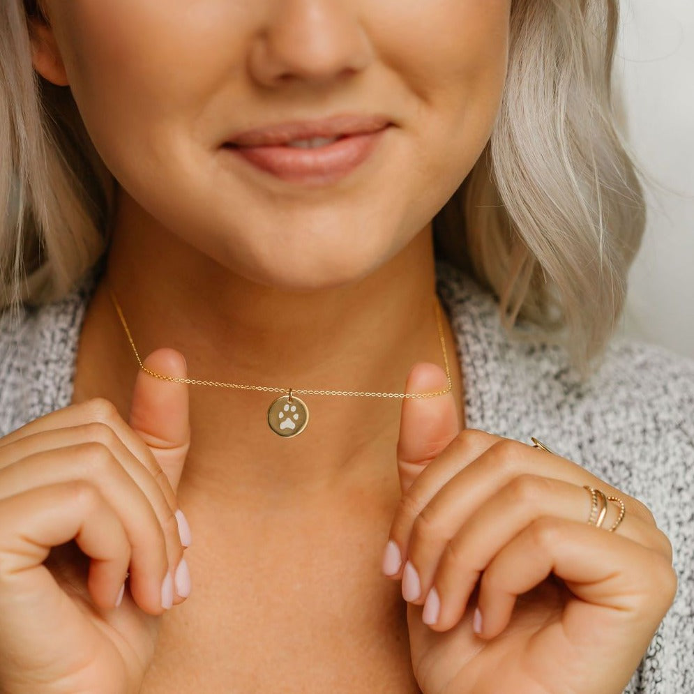 Fur Mama showing her custom paw print necklace with her dogs actual paw engraved